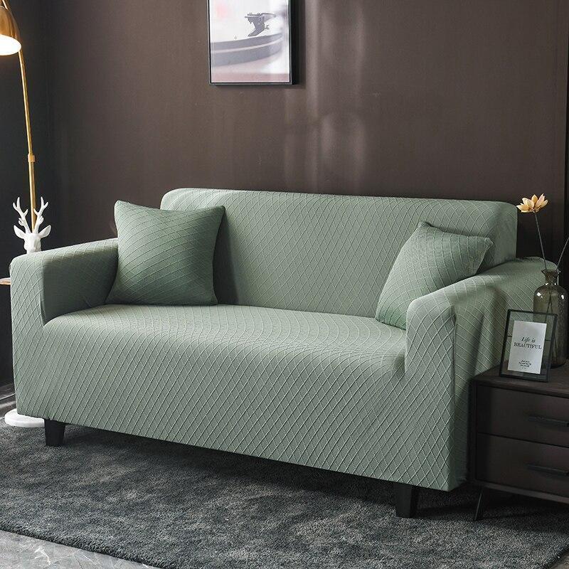 Pale green wide jacquard couch cover with two matching pillows on a sofa.