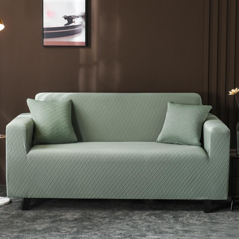 Pale green wide jacquard couch cover with two matching pillows on a sofa.