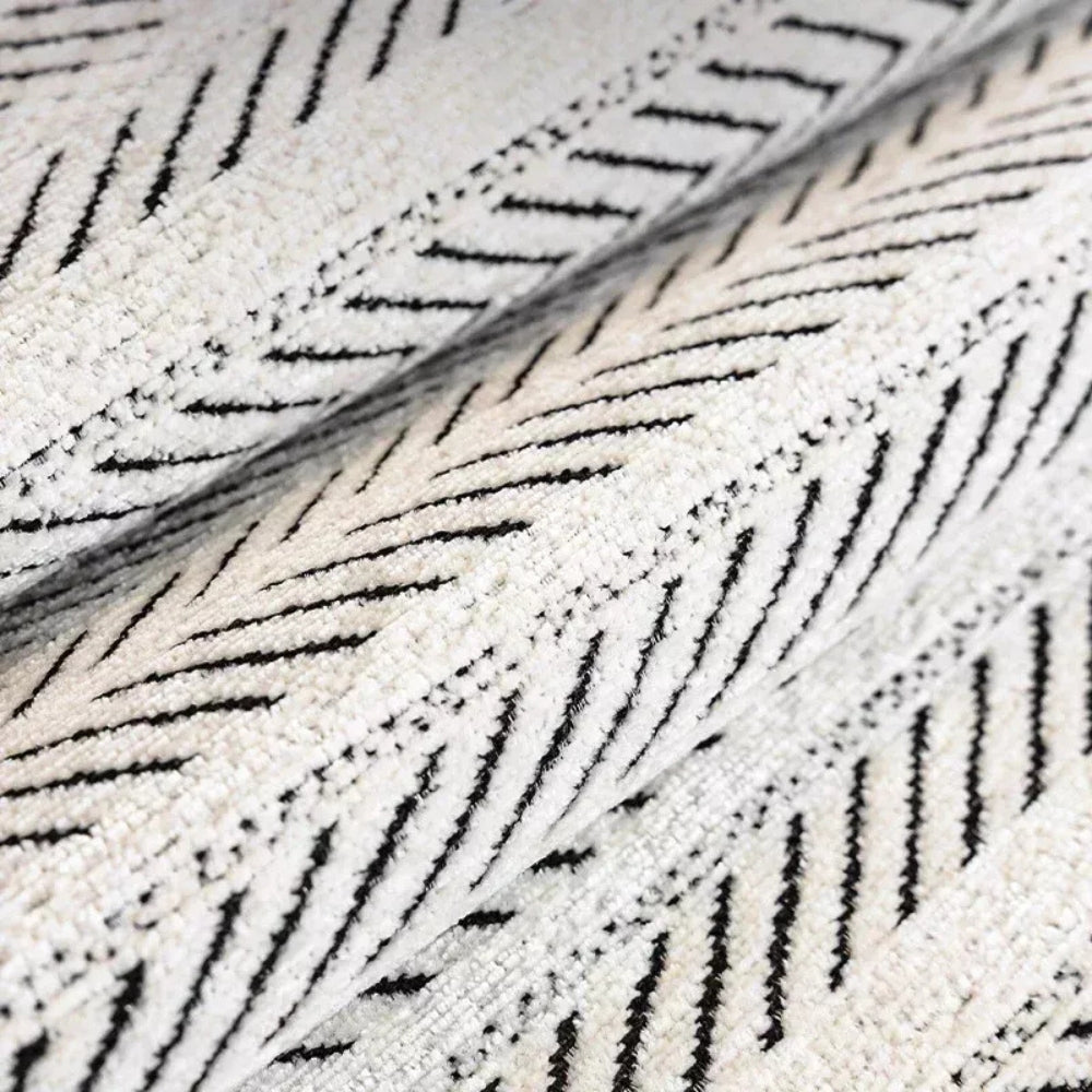 White sofa cover with a black herringbone pattern, folded to show texture.
