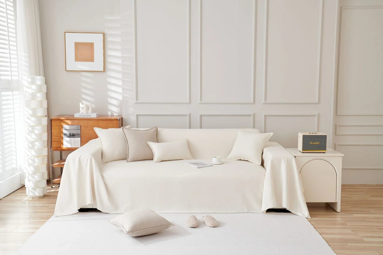 Off-white soft throw blanket draped over a sofa with decorative pillows.