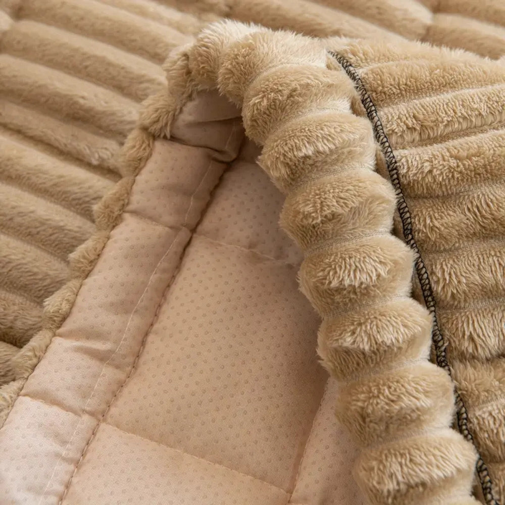 Close-up of a plush sofa cover with hand-pleated edges and a non-slip backing.