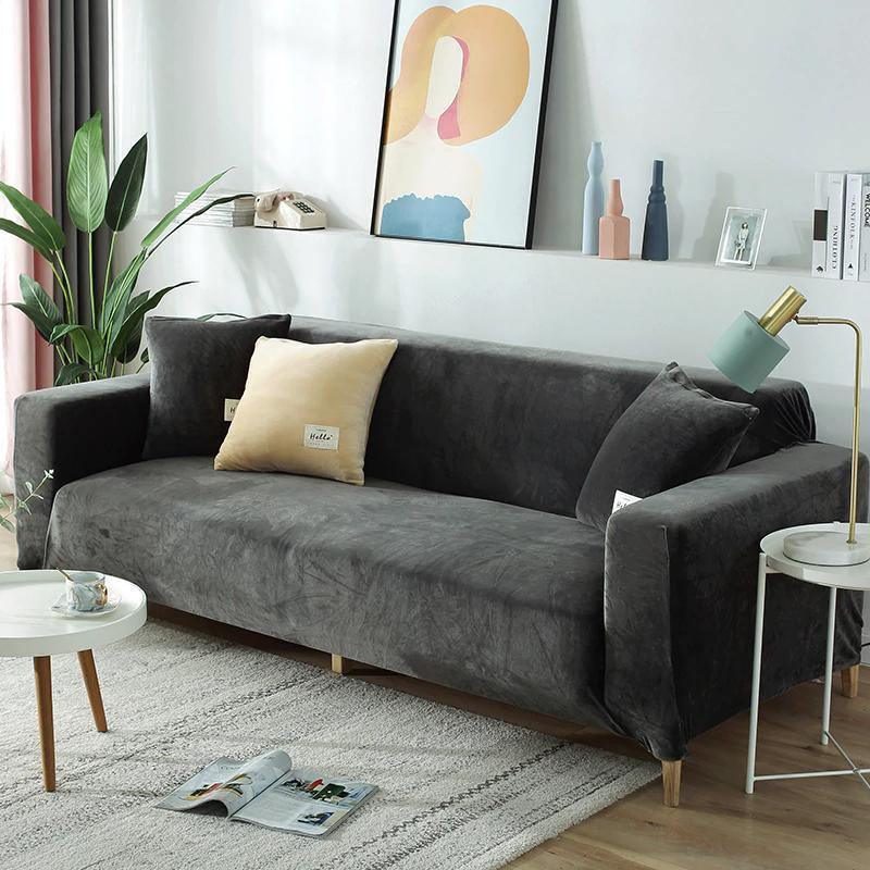 Grey velvet couch cover with two pillows on a sofa in a living room.