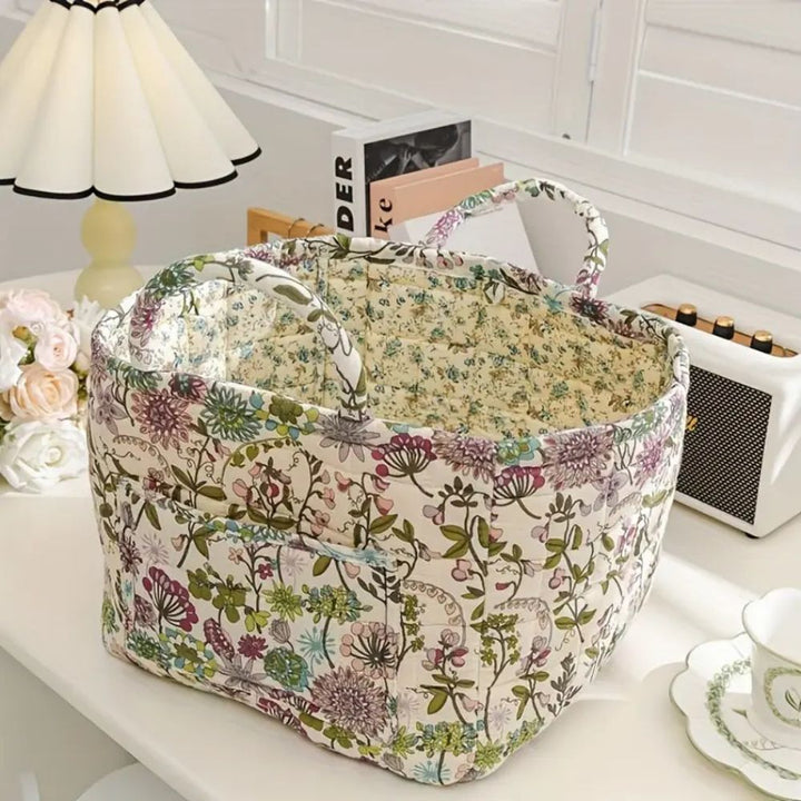 Floral canvas storage basket with handles, open top, and quilted exterior.