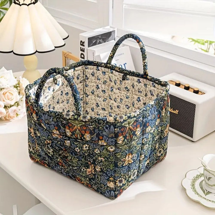 Floral canvas storage basket with handles, featuring a dark blue and green floral pattern.