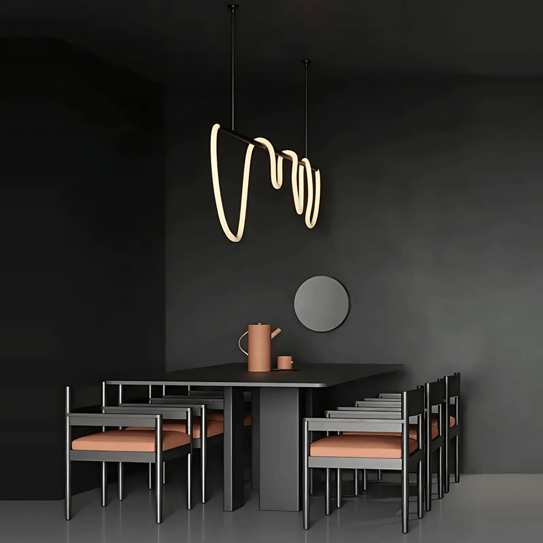 Black modern chandelier with a wavy silicone LED rope hanging above a dark dining table with chairs.