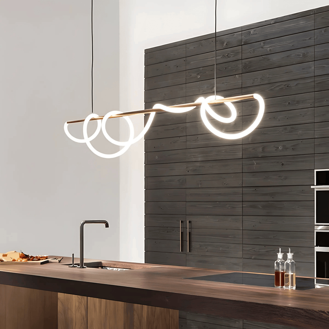 Black chandelier with a swirling silicone LED rope design suspended over a wooden kitchen island.