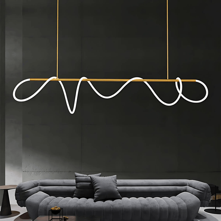 Modern black chandelier with a wavy silicone LED rope and gold accents, suspended above a grey sofa.