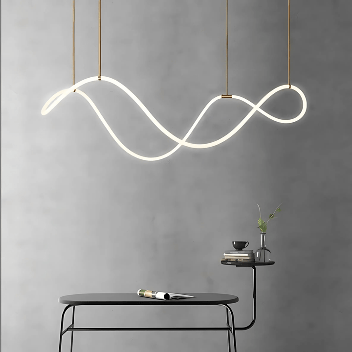 Modern black chandelier with a flowing, wavy design, suspended by thin cords against a gray wall.