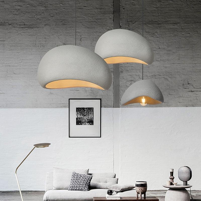 Three Wabi-Sabi pendant lights in rustic grey hang above a sofa and coffee table.