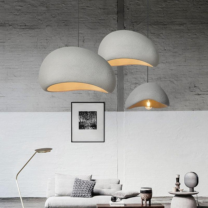 Three Wabi-Sabi pendant lights in rustic grey hang above a sofa and coffee table.