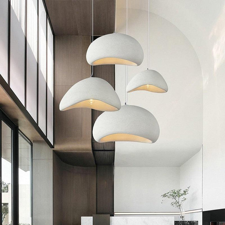 Four off-white Wabi-Sabi pendant lights with textured surfaces hang at different heights.