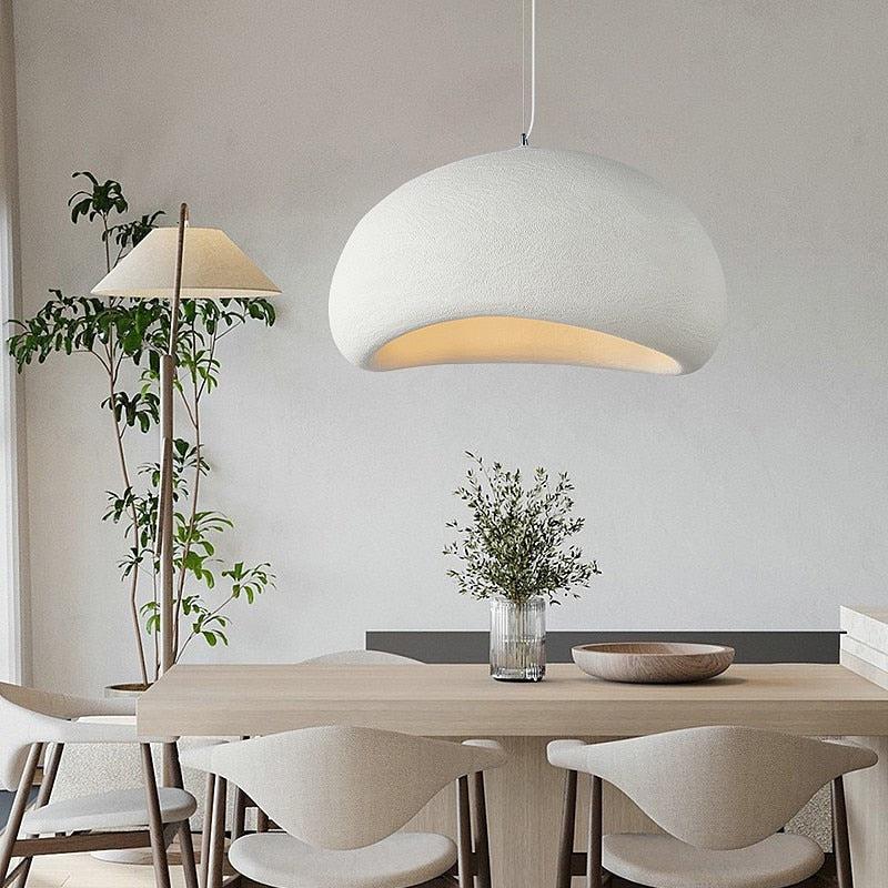 Wabi-Sabi pendant light in off-white, hanging over a wooden dining table with chairs.