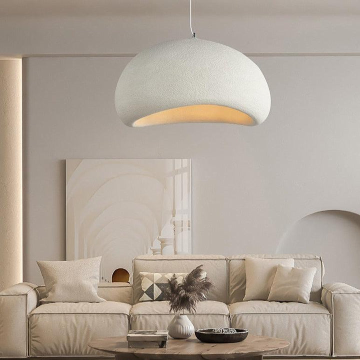 Wabi-Sabi pendant light with a textured, off-white dome shade hanging over a neutral-toned sofa.