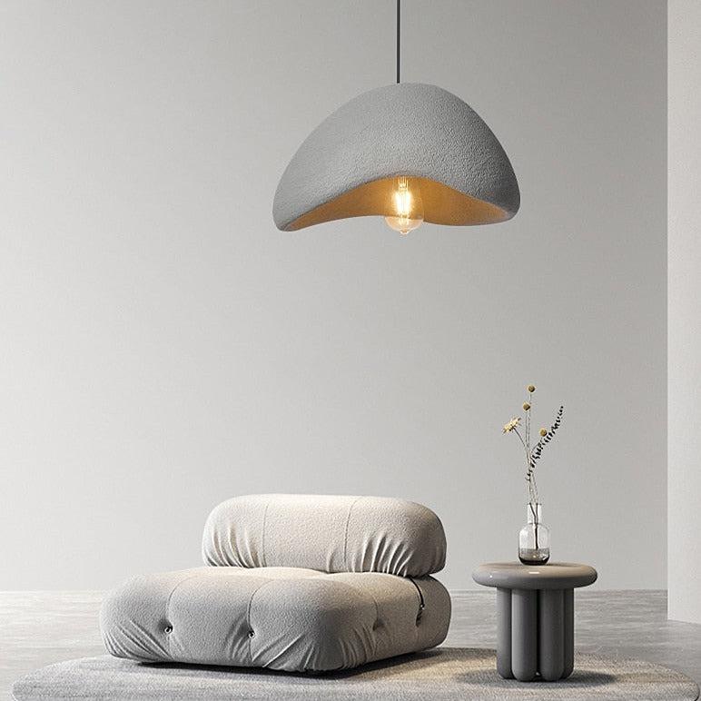 Wabi-Sabi pendant light in rustic grey, illuminating a minimalist chair and side table.