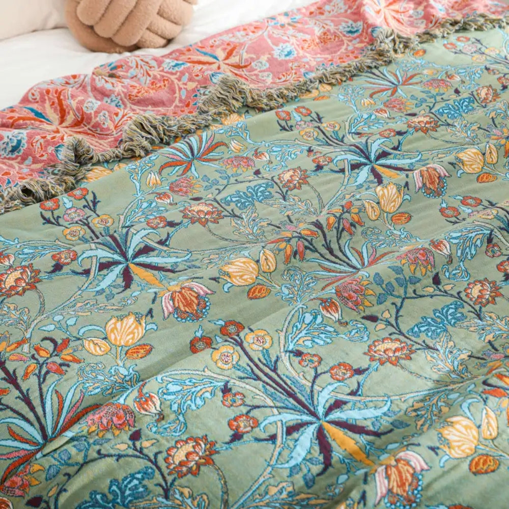 Greenery floral cotton tassel blanket with pink floral pattern on top and green floral pattern below.