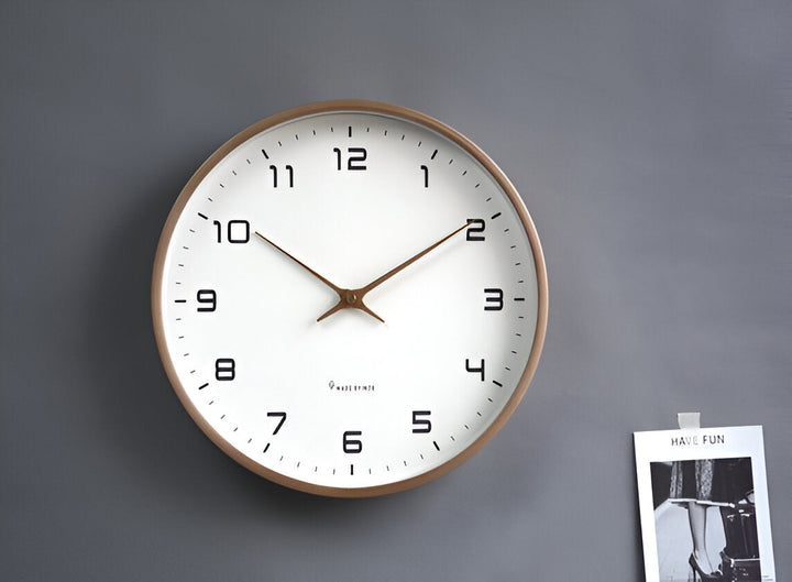 Nordic Wood Wall Clock with a white face, black numbers, and a light wood frame, hanging on a gray wall.
