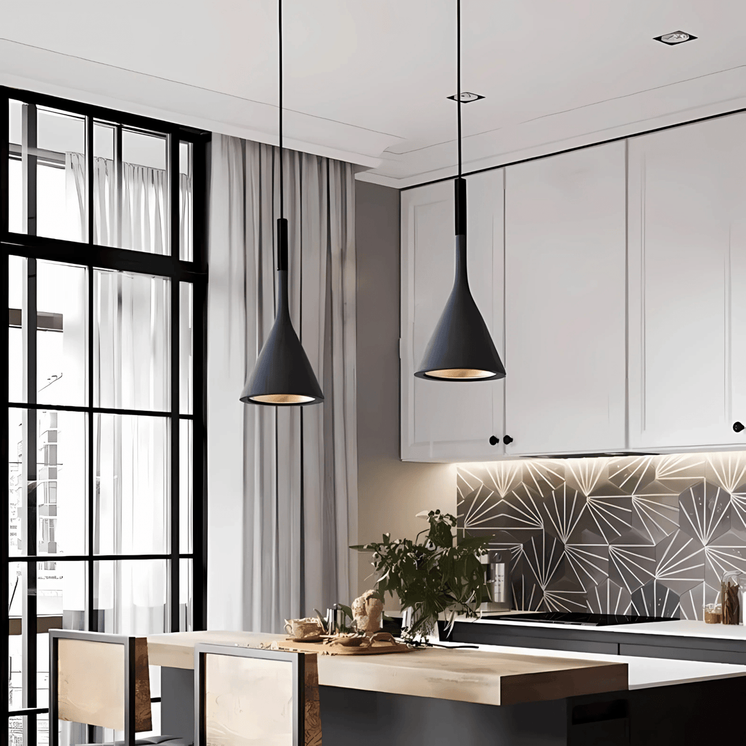 Two black cone pendant lights hang over a kitchen island with a wooden countertop.