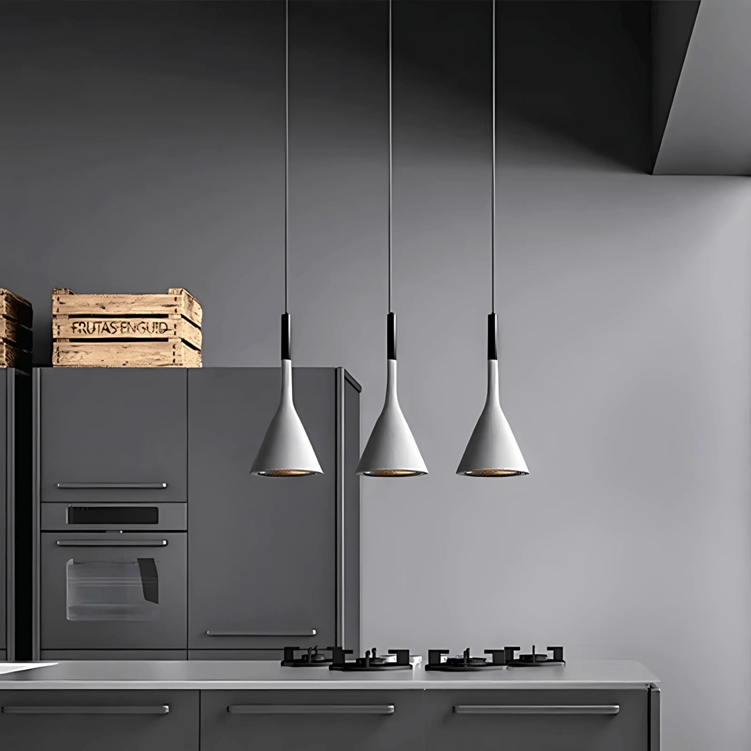 Three white cone pendant lights hanging over a modern kitchen counter.
