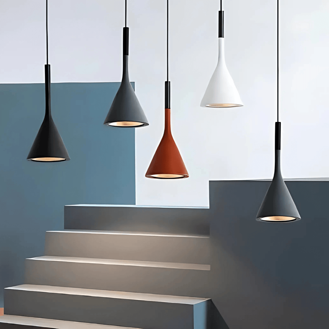 Five cone-shaped pendant lights in black, gray, rust, and white hanging above a staircase.