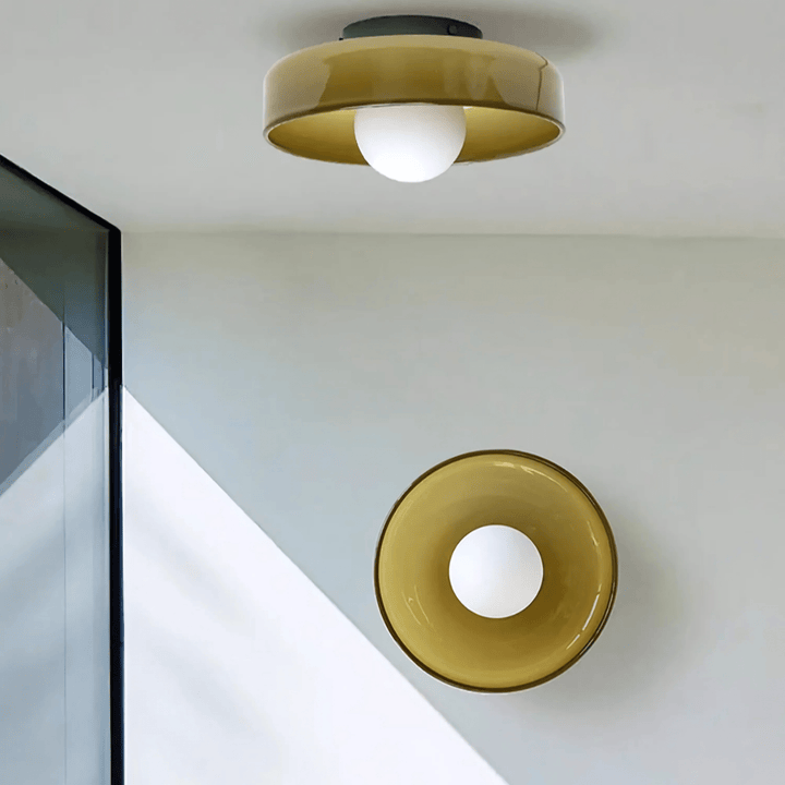 Flush mount ceiling light with a golden shade and a white globe bulb.