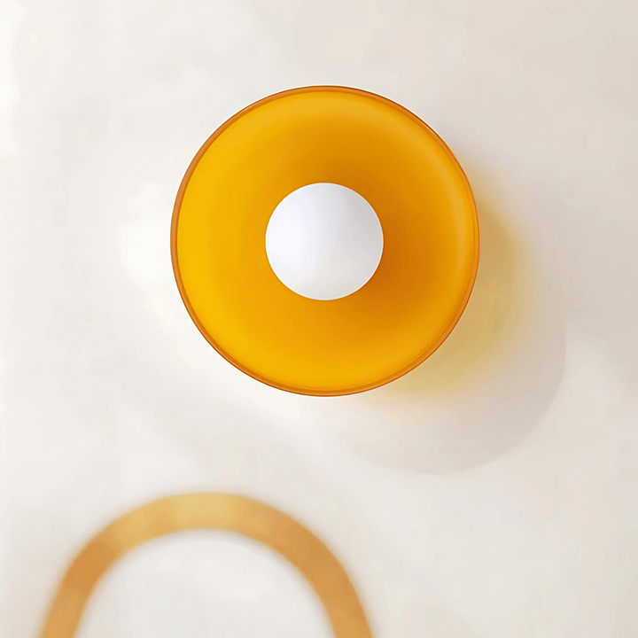 Orange flush mount ceiling light with a white bulb in the center.