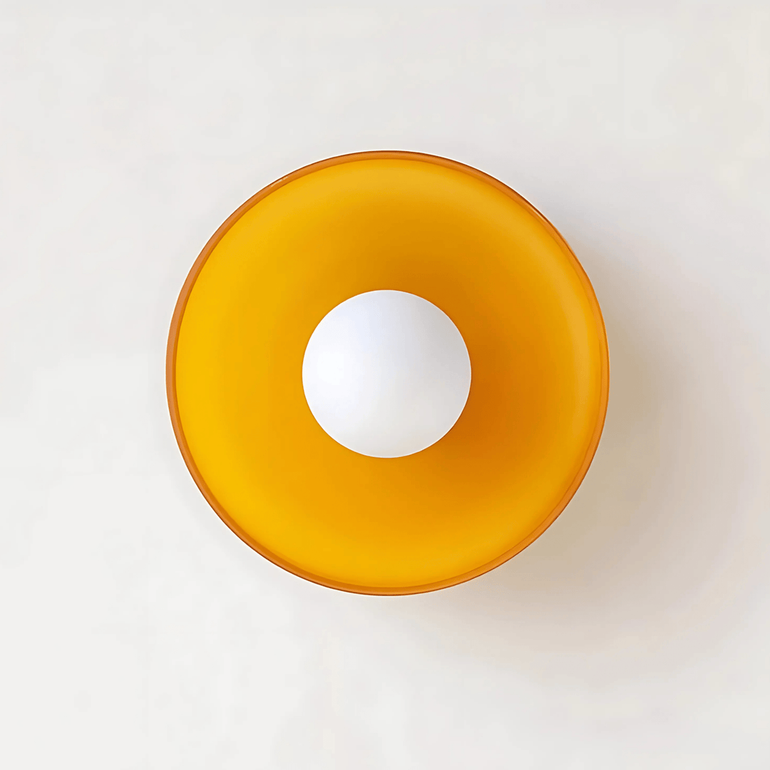 Round flush mount ceiling light with an amber glass shade and a white globe bulb in the center.