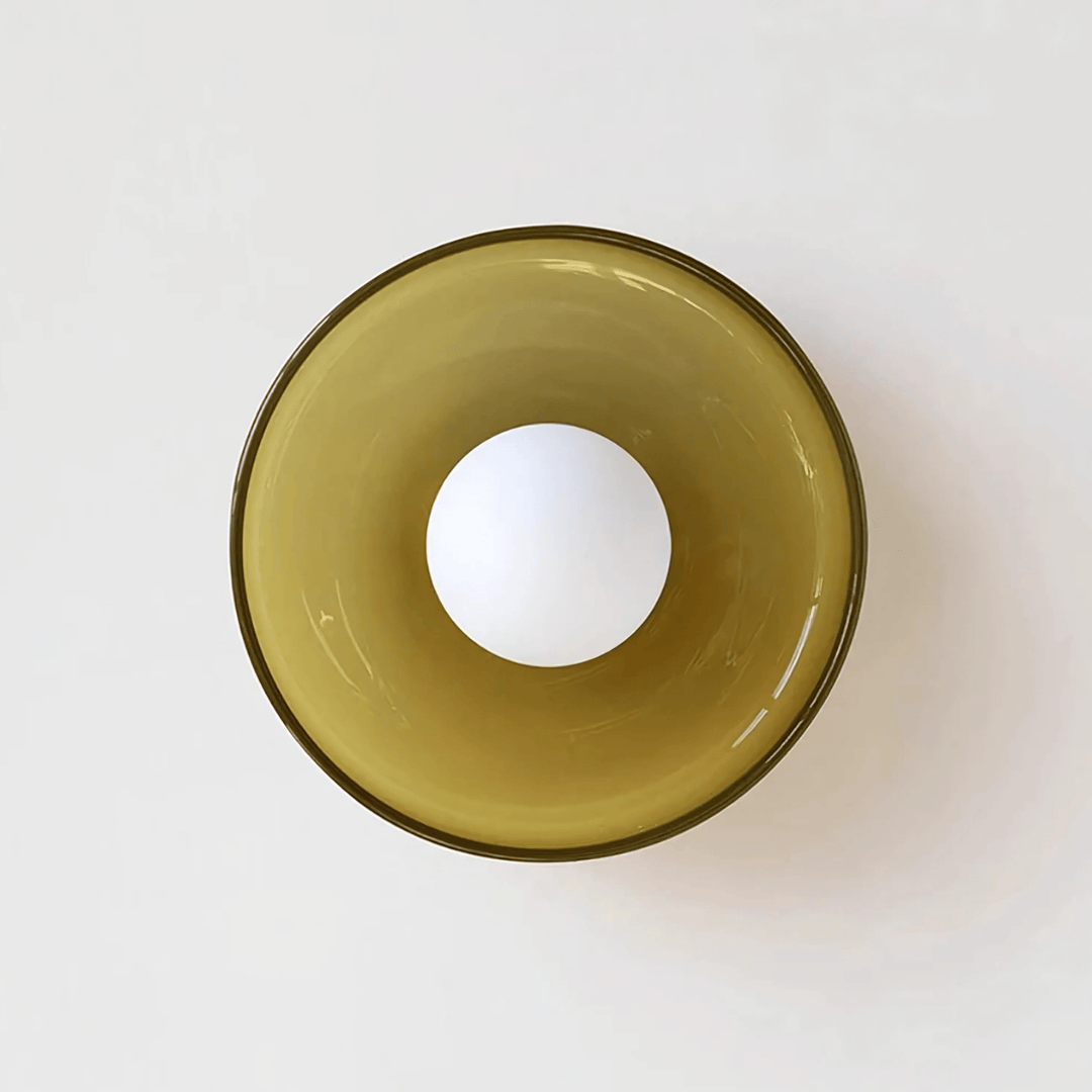 Flush mount ceiling light with a translucent amber glass shade and a white bulb.
