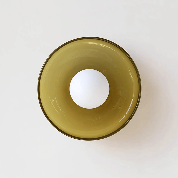 Flush mount ceiling light with a translucent amber glass shade and a white bulb.