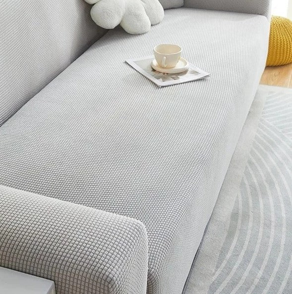 Light grey narrow jacquard couch cover with a textured pattern.