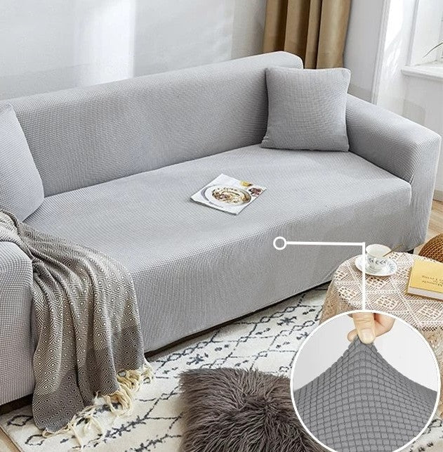 Light grey narrow jacquard couch cover with a textured pattern, shown on a sofa.