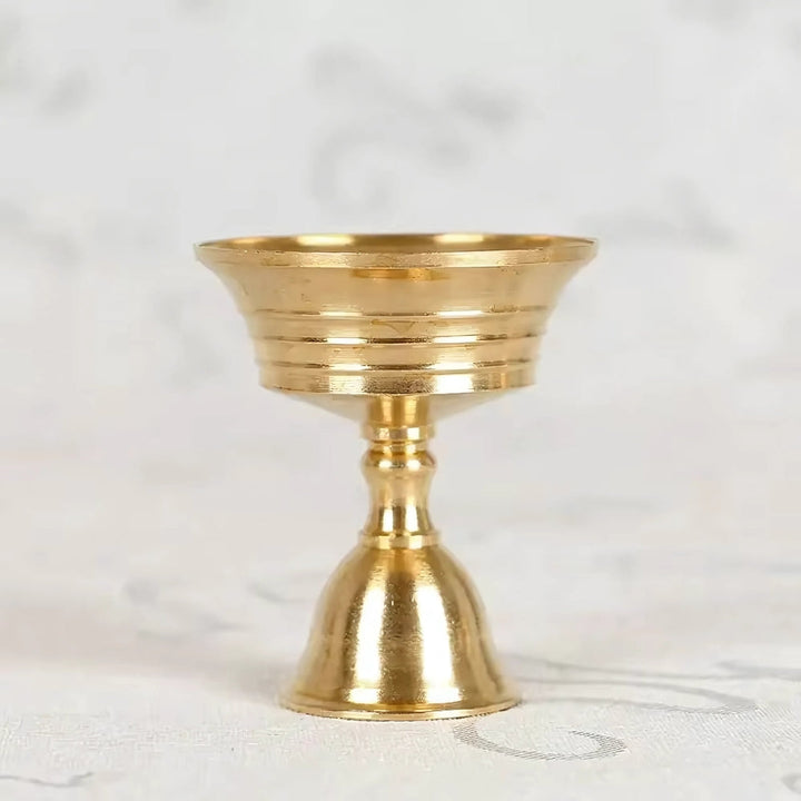 Vintage copper cup candle holder with a pedestal base and fluted rim.