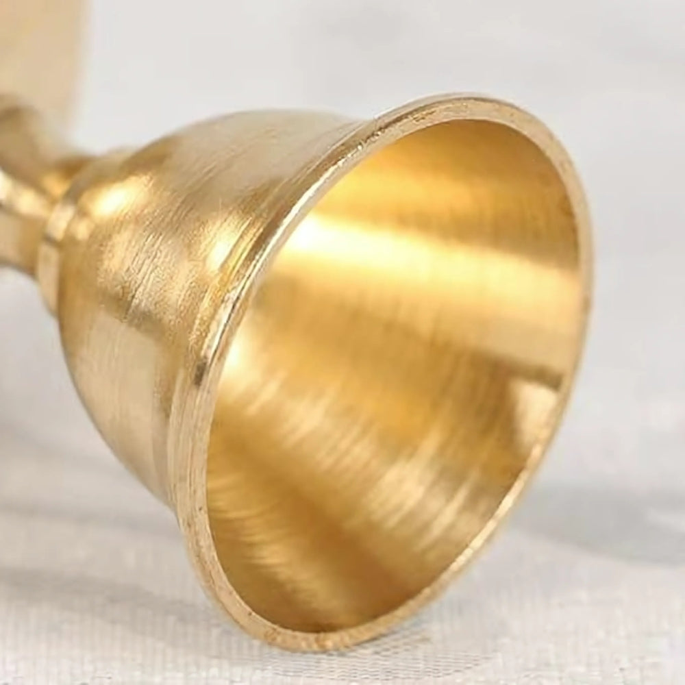 Close-up of a vintage copper cup candle holder with a brushed finish.