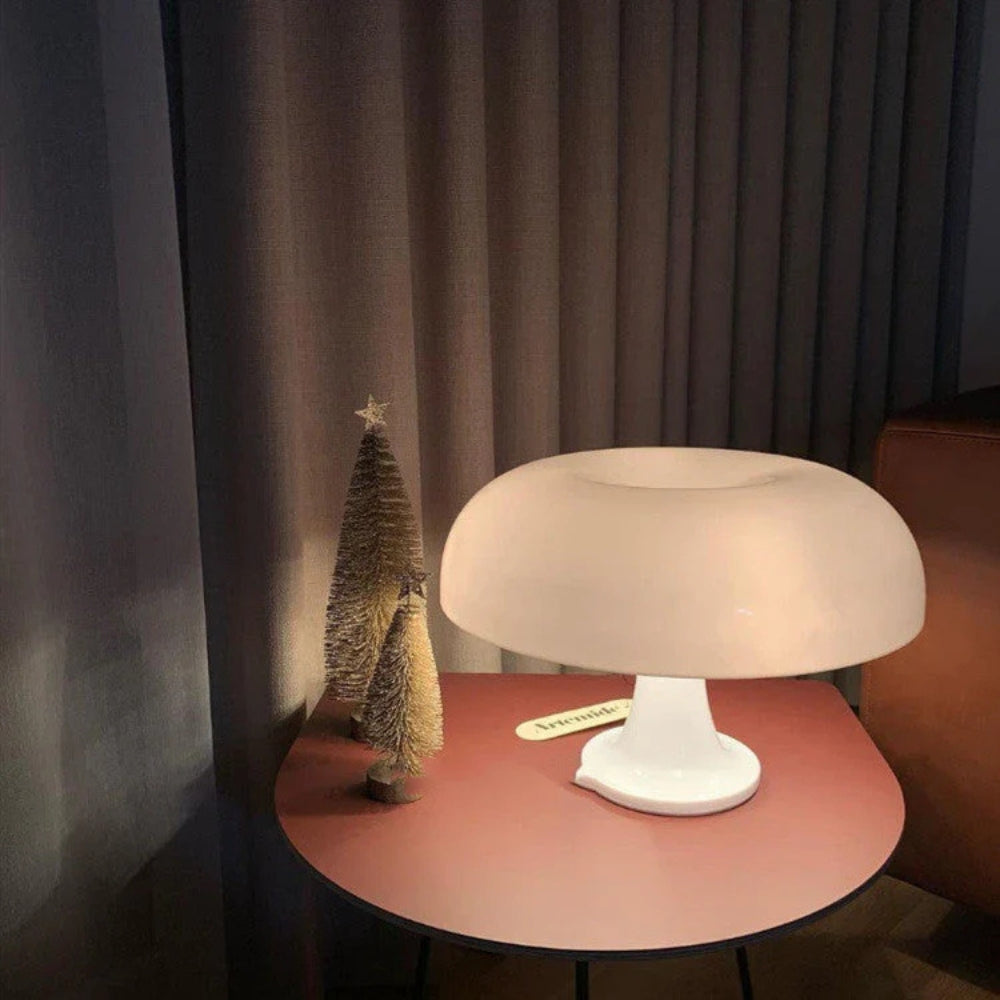 White mushroom-shaped LED table lamp on a red side table with two small decorative trees.