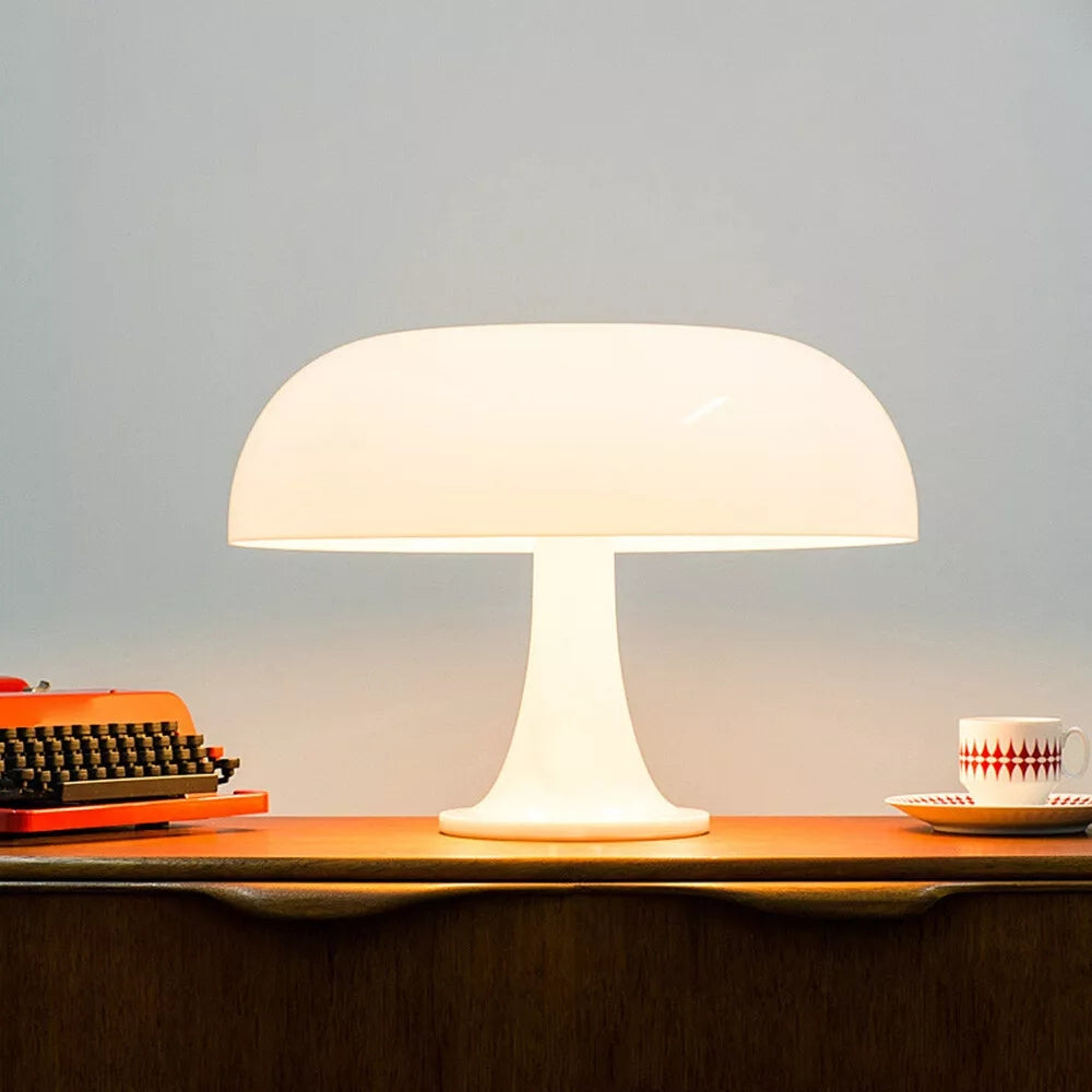White mushroom-shaped LED table lamp on a wooden surface with a vintage typewriter and a teacup.
