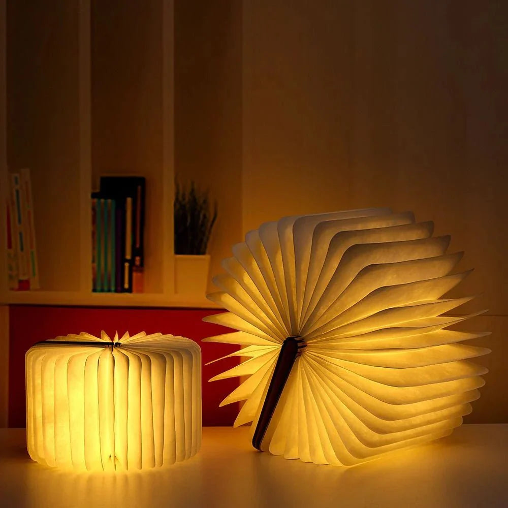 Two LumiFold table lamps, one closed and one open like a fan, casting a warm glow.