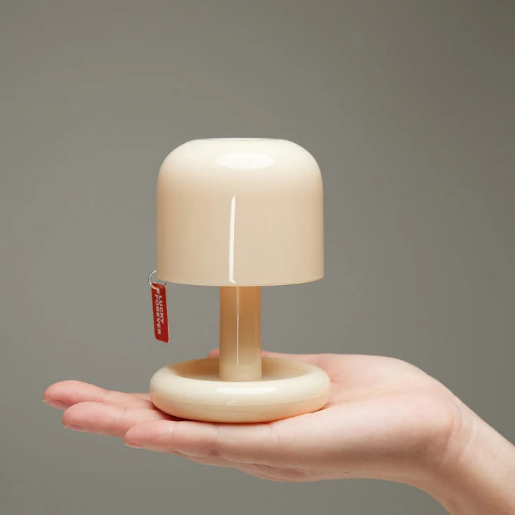 Cream colored USB rechargeable table lamp with a red tag that says &