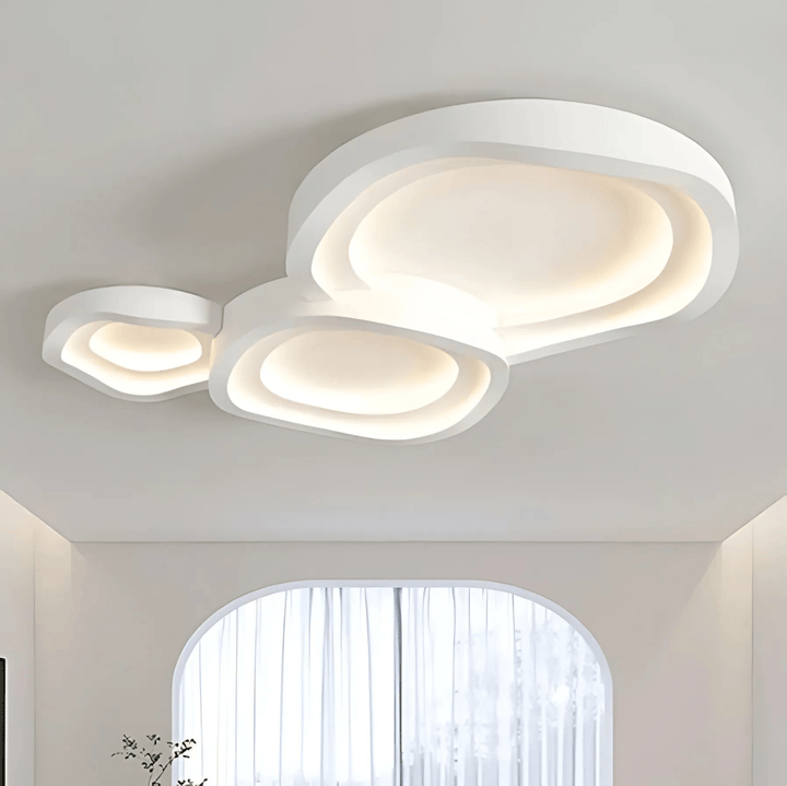 White contemporary metal flush mount ceiling light with three organically shaped layers.
