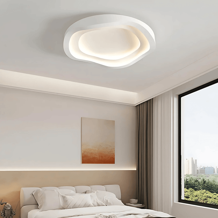 Contemporary metal flush mount ceiling light with an organic, layered design in a bedroom.