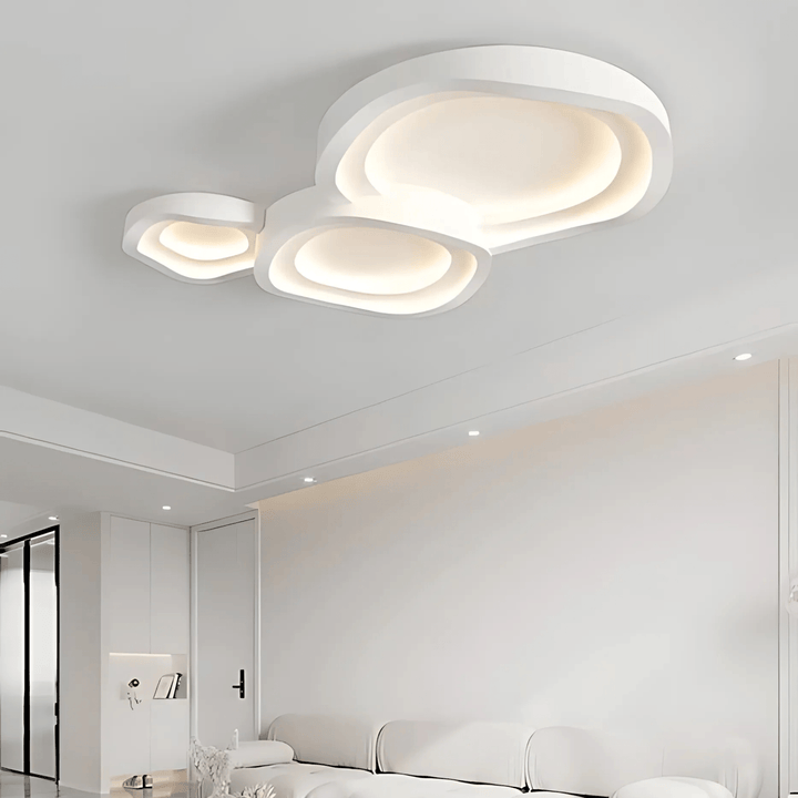 Contemporary white metal flush mount ceiling light with layered, organic shapes and integrated LED illumination.