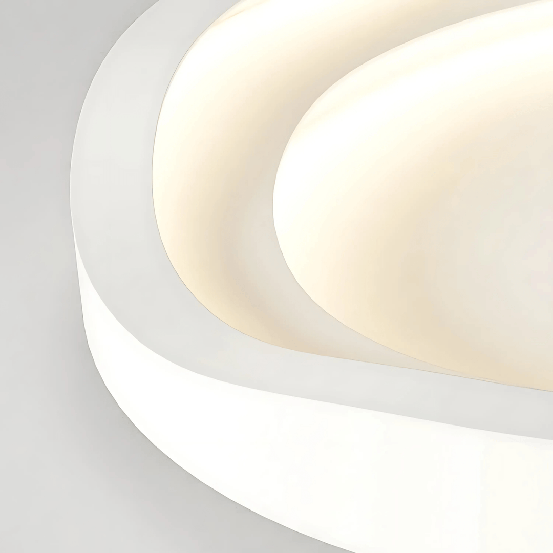 Metal flush mount ceiling light with curved, layered design in white and cream.