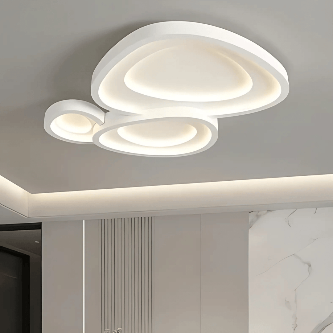 Contemporary white metal flush mount ceiling light with layered, organic shapes and integrated LED illumination.