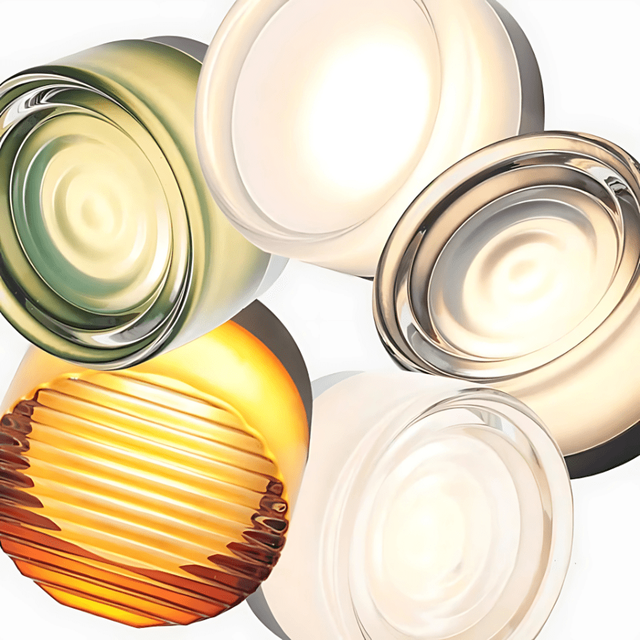 Collection of five glass sconce lights in various colors and textures, including green, amber, and clear.