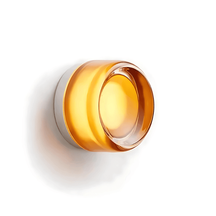 Metal and amber glass wall sconce with a modern, circular design.