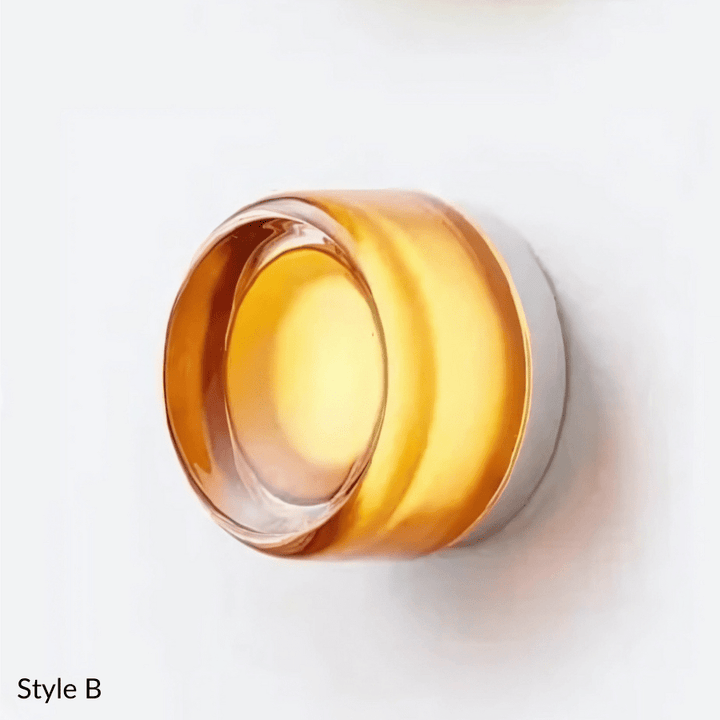 Style B wall sconce with a round, amber glass shade and a silver metal base.