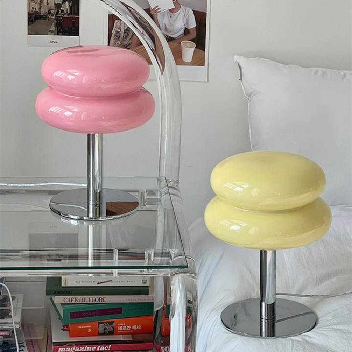 Pink and yellow retro glass table lamps with chrome bases on a nightstand.