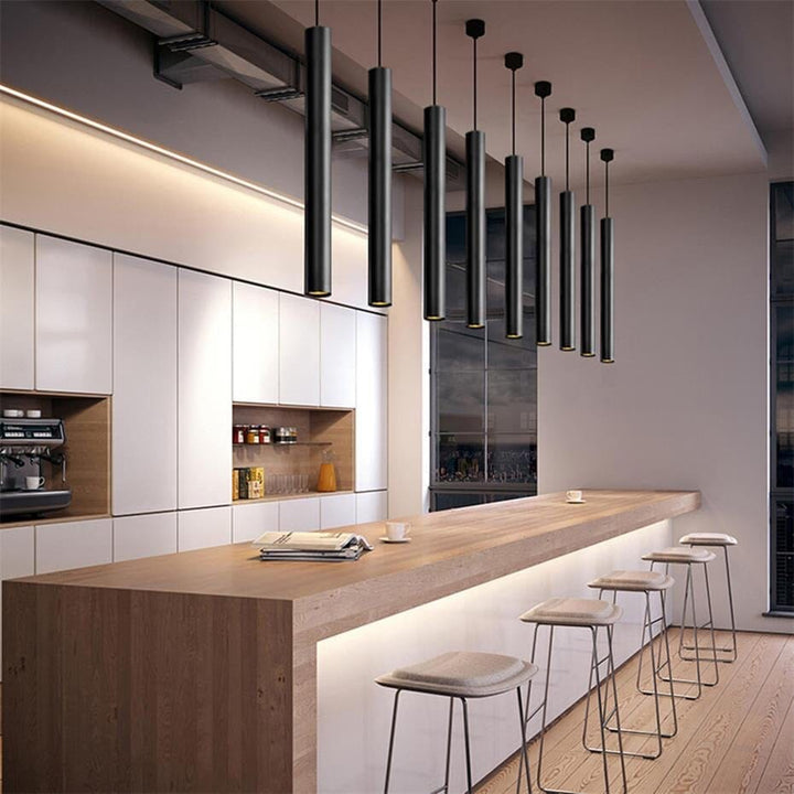 Black adjustable pendant light hanging over a wooden kitchen island with stools.