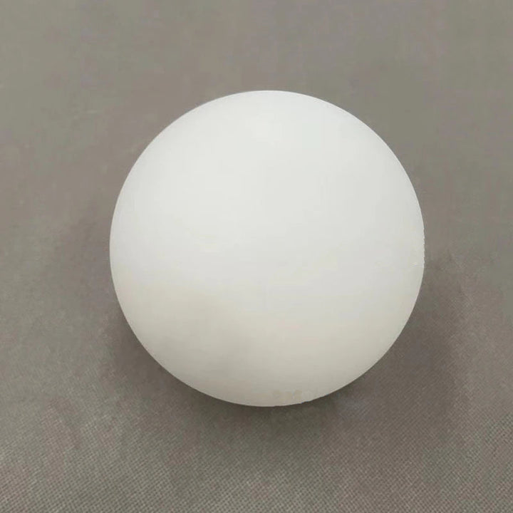 A round, white, frosted glass shade for a wall sconce.
