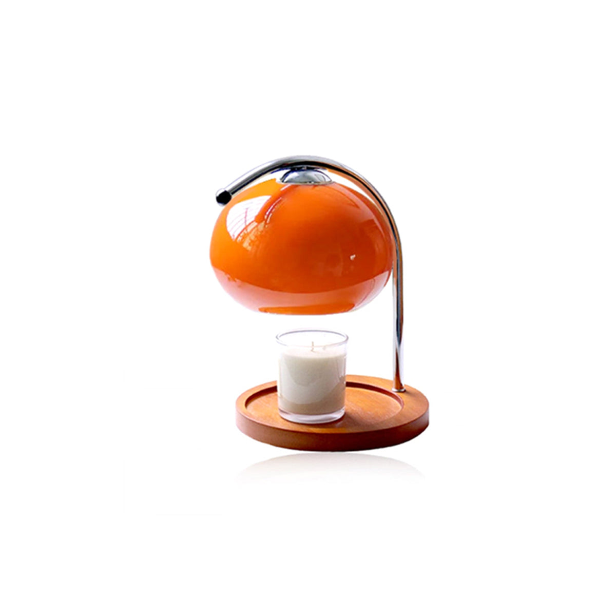 Orange glass globe candle warmer with a metal stand on a wooden base, holding a lit candle.