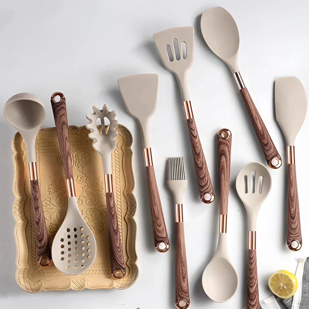 A 10-piece set of beige silicone kitchen utensils with wood-grain handles and rose gold accents, arranged on a white surface.