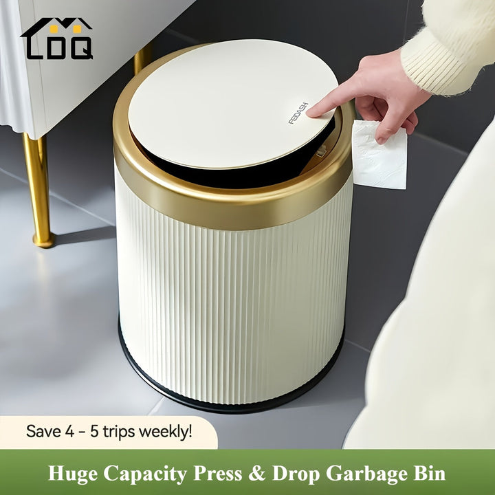 Cream and gold press-top trash can with a fluted design, a hand pressing the lid.